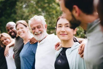 Decorative image of older adults and adults linked at the shoulders smiling.